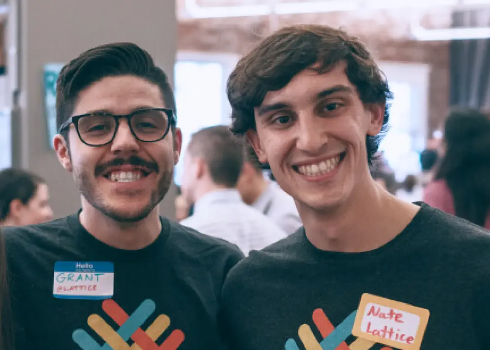two men wearing t - shirts with stickers on them